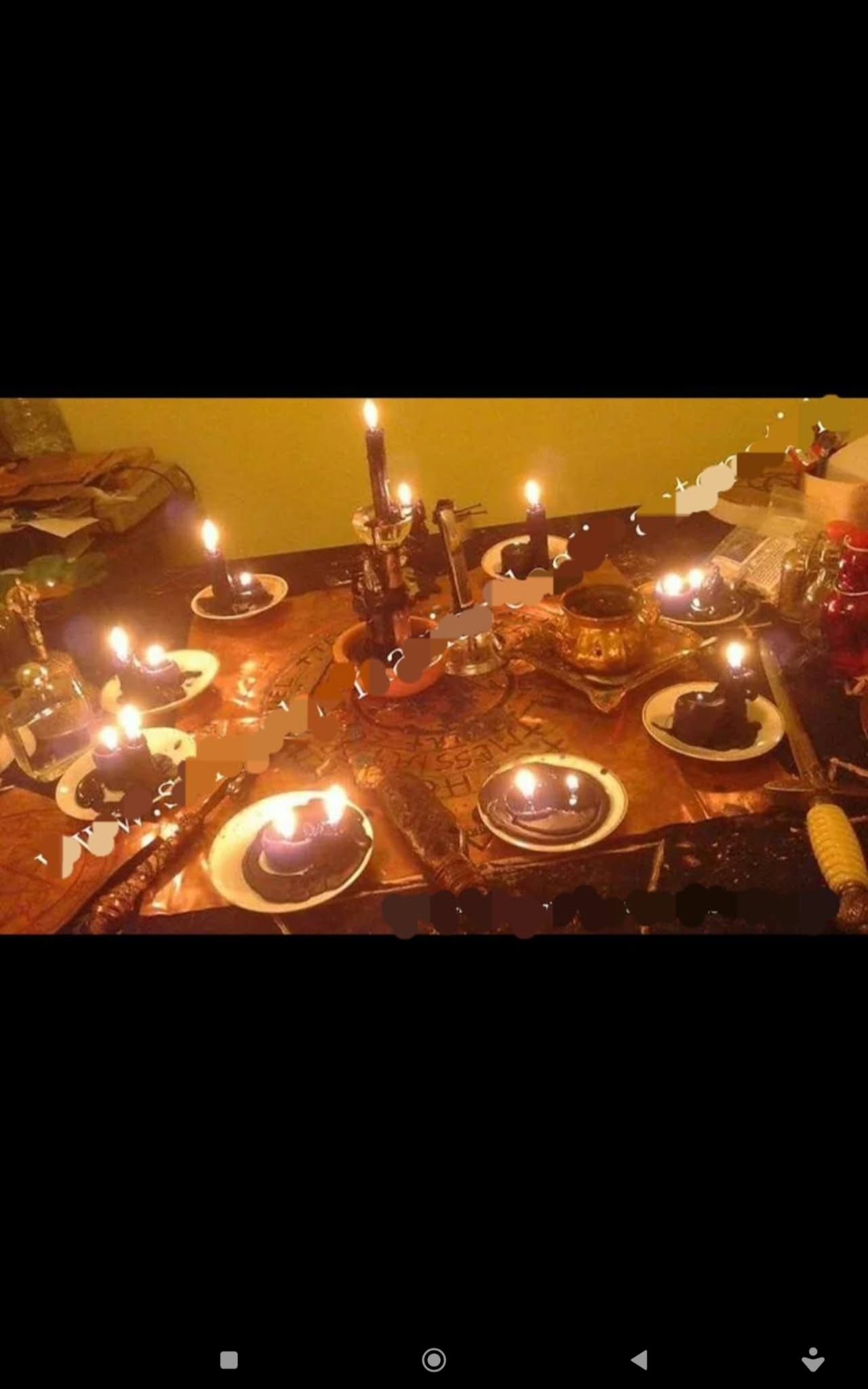A wide candlelit tabletop display with plates, vessels, candles and warm orange lighting.