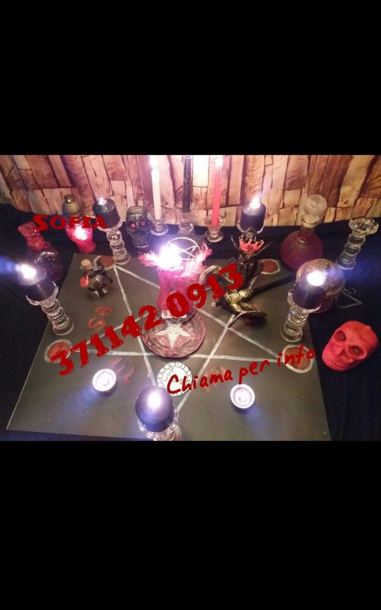 A wide overhead view of a candlelit tabletop arrangement with colored vessels and small decorative objects in a dim wooden setting.