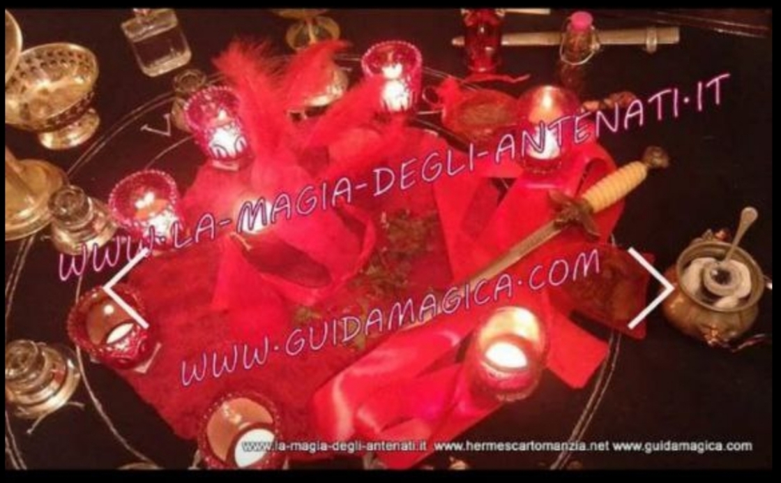 A red-themed tabletop arrangement with candles, feathers and small decorative objects, covered by large promotional website text.