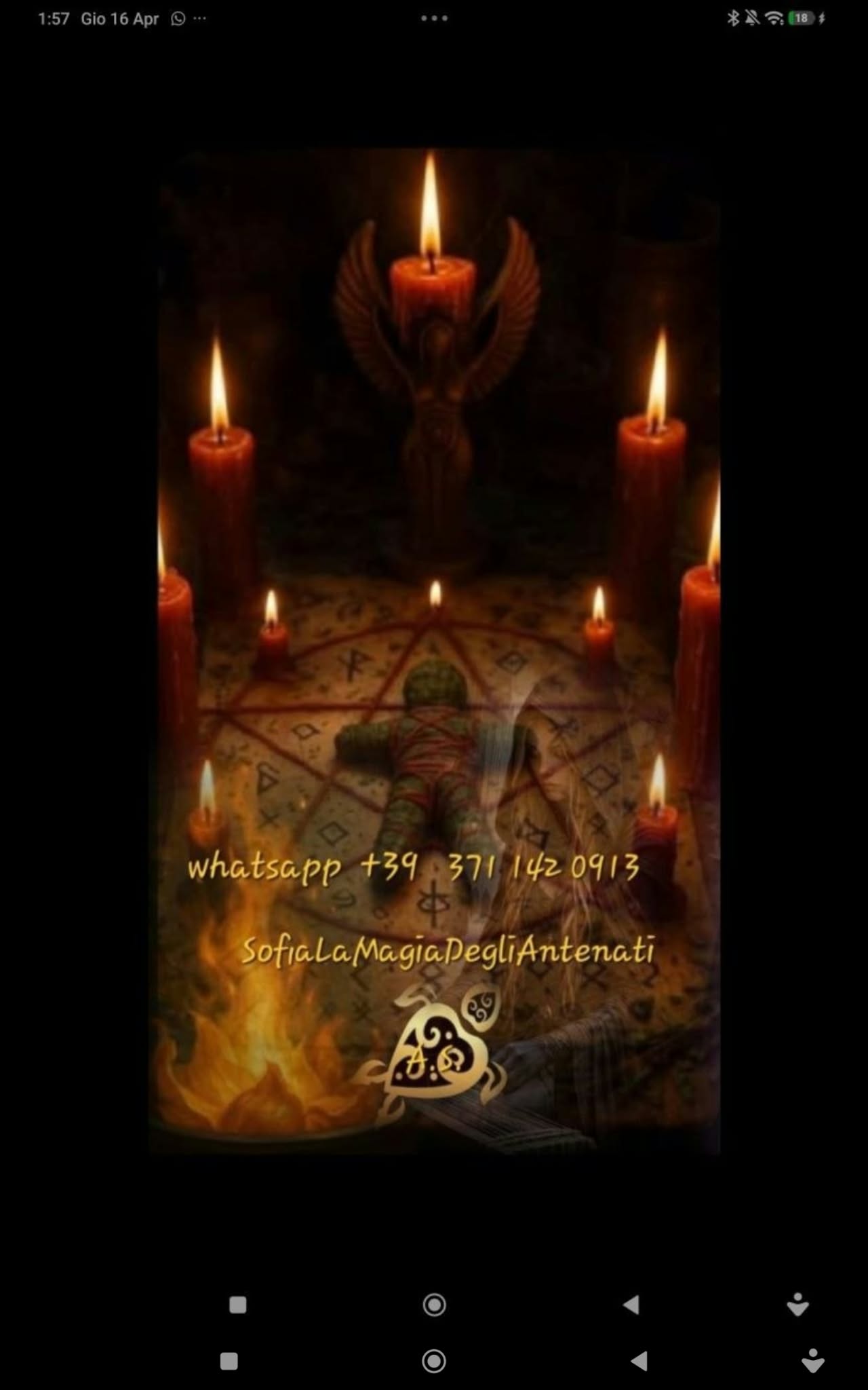 Candle arrangement around a central circular surface and object, framed vertically in dim warm candlelight.