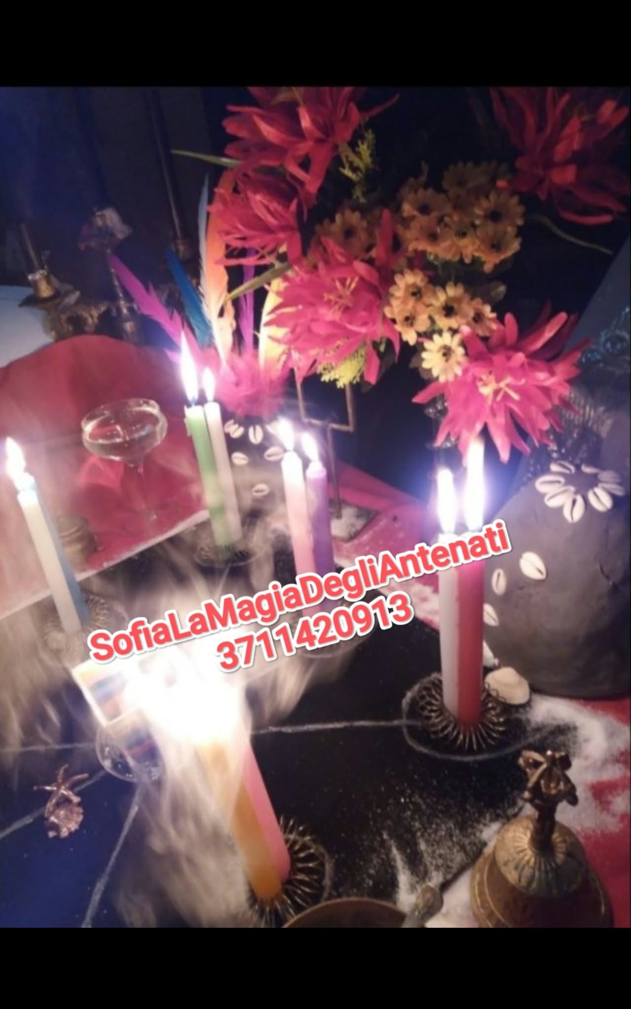 A tabletop display of lit candles, colorful flowers and decorative objects, photographed in dim light with a bright flame and promotional text overlay.
